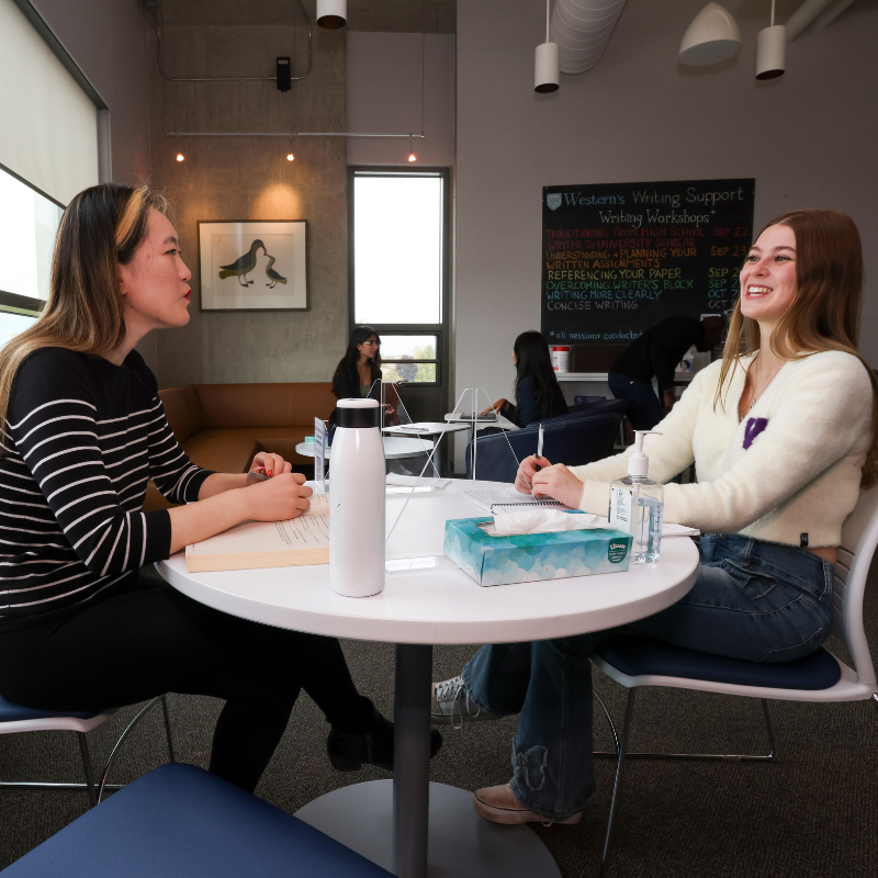 A student receives writing feedback from an advisor.