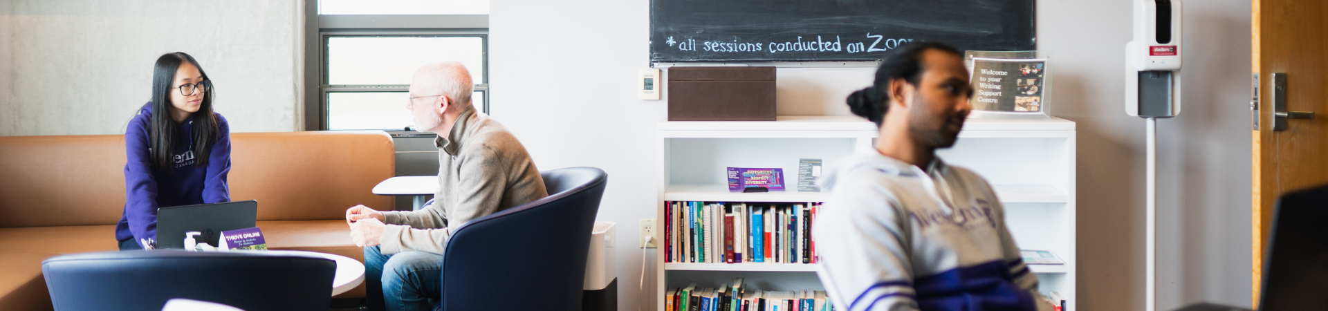 A group of students greet eachother outside.