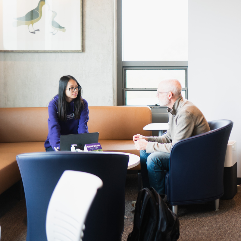 A group of students greet eachother outside.